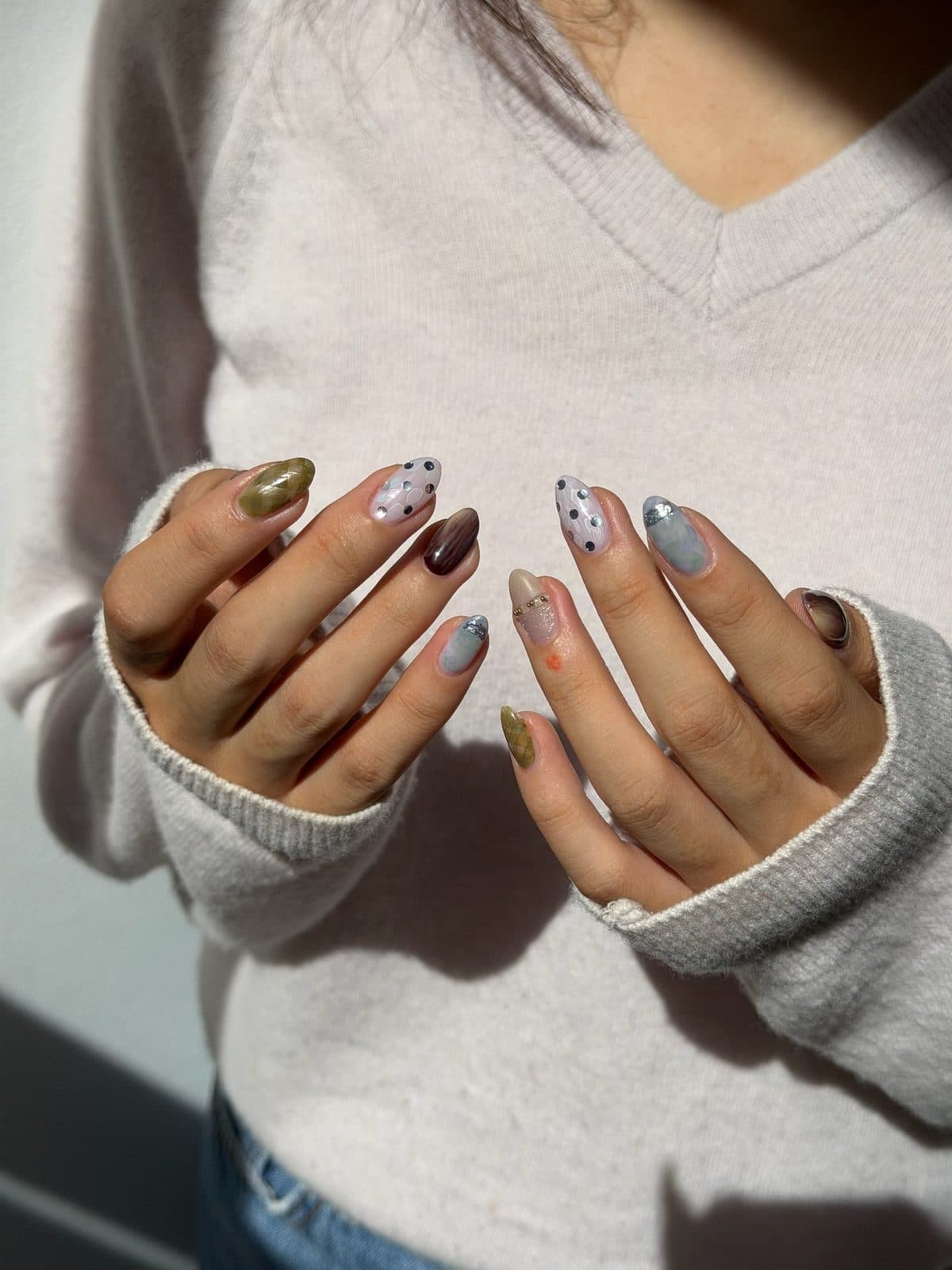 Almond gel nails mixing olive, charcoal and dotted pastel designs at Joy Nail Studio Vancouver