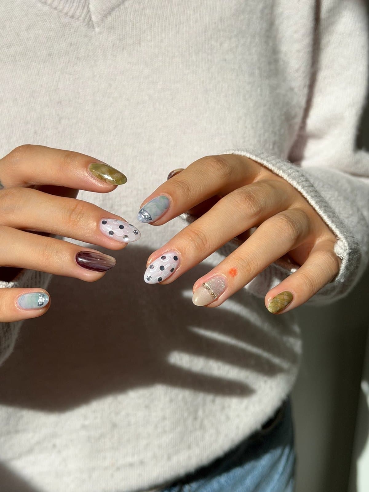 Short round gel nails in sage, mauve and cream with fine dot art at Joy Nail Studio Vancouver