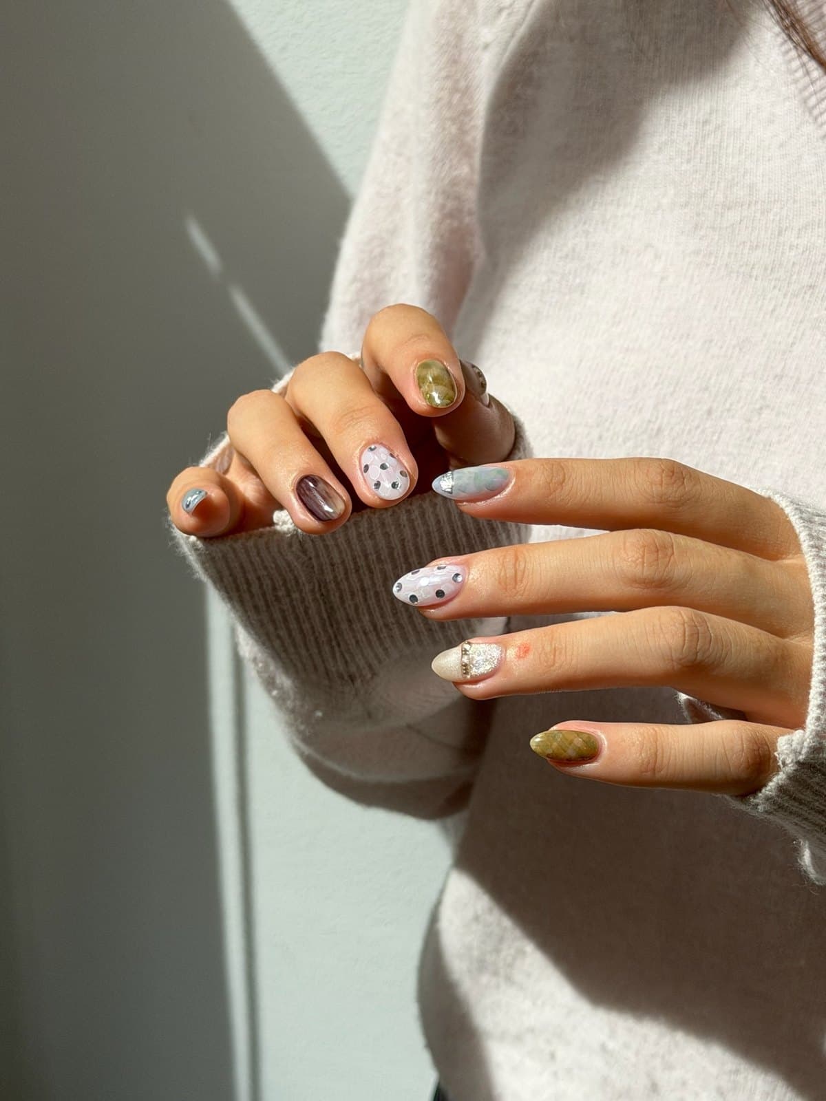 Gel nails in olive and grey with speckled and dotted accents at Joy Nail Studio Vancouver