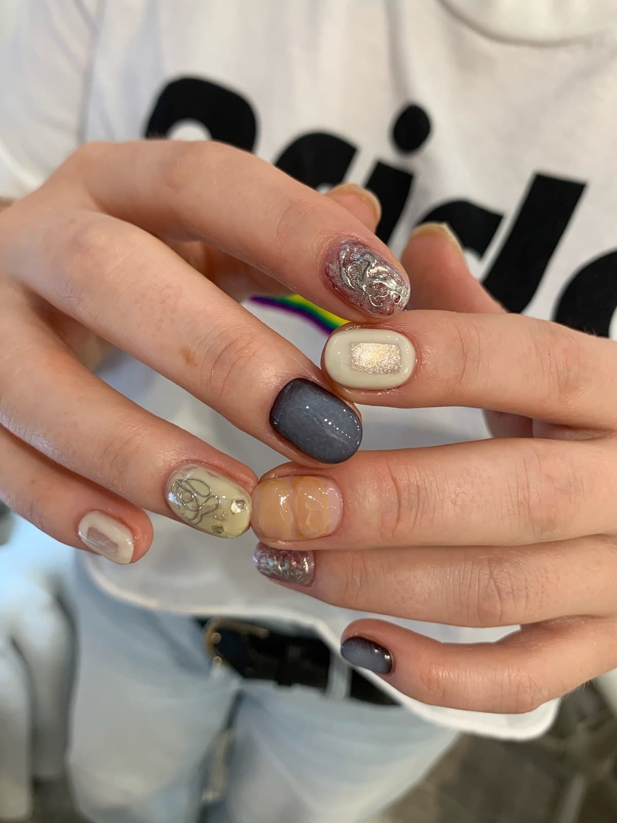 Gel nails mixing amber, grey and silver foil with a mirror-chrome accent at Joy Nail Studio Vancouver