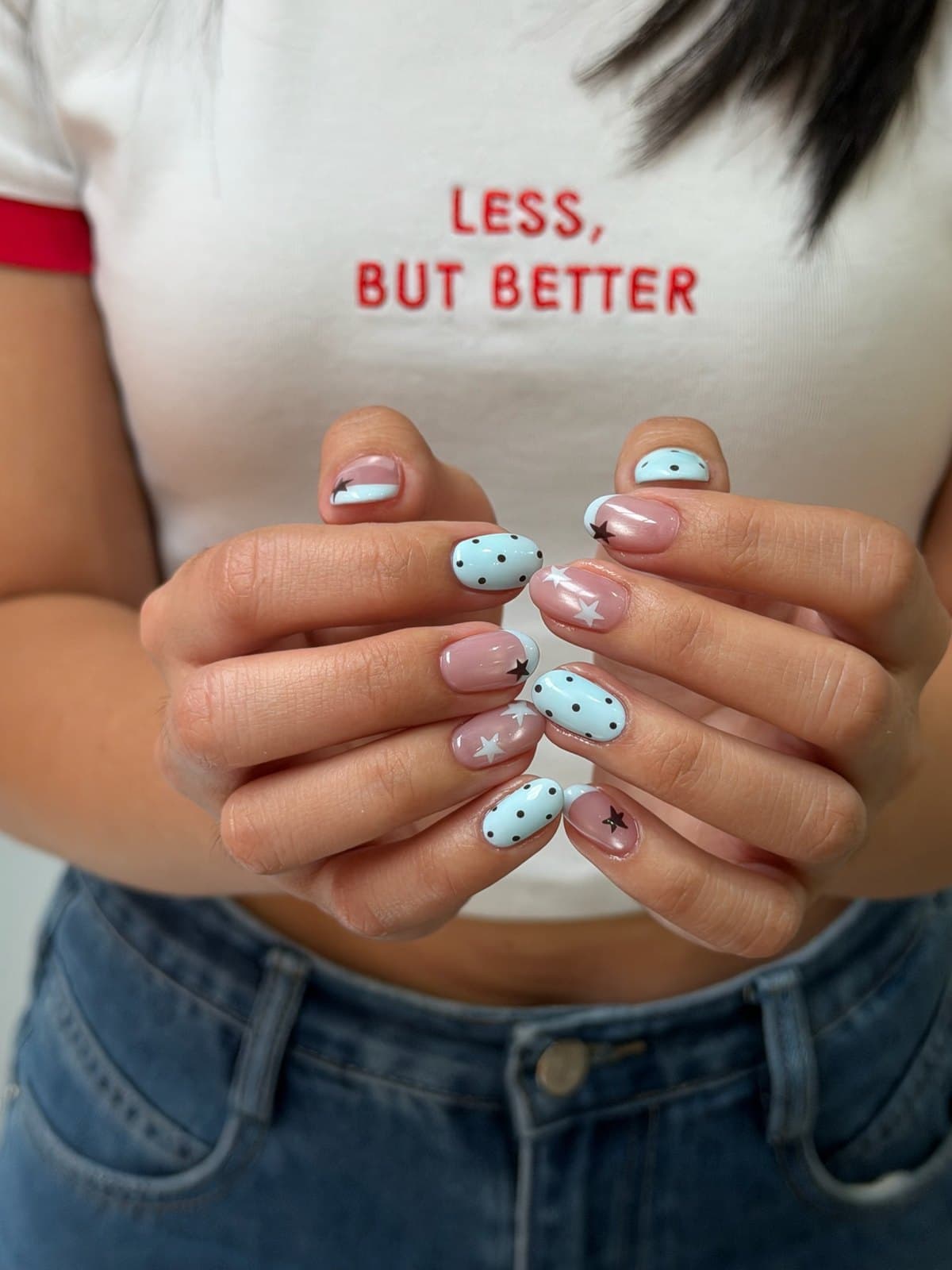 Sheer gel nails in pale blue with black dots and a star accent at Joy Nail Studio Vancouver