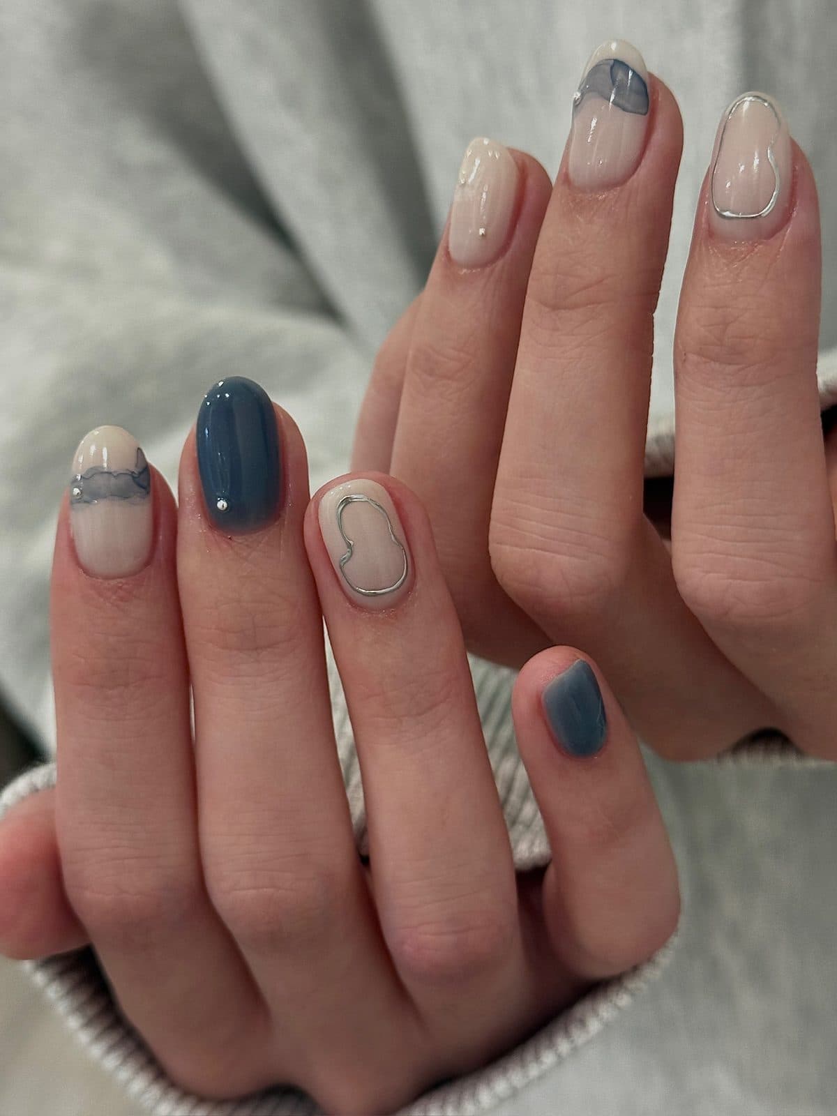 Short round gel nails in denim blue and milky nude with silver wire outlines at Joy Nail Studio Vancouver