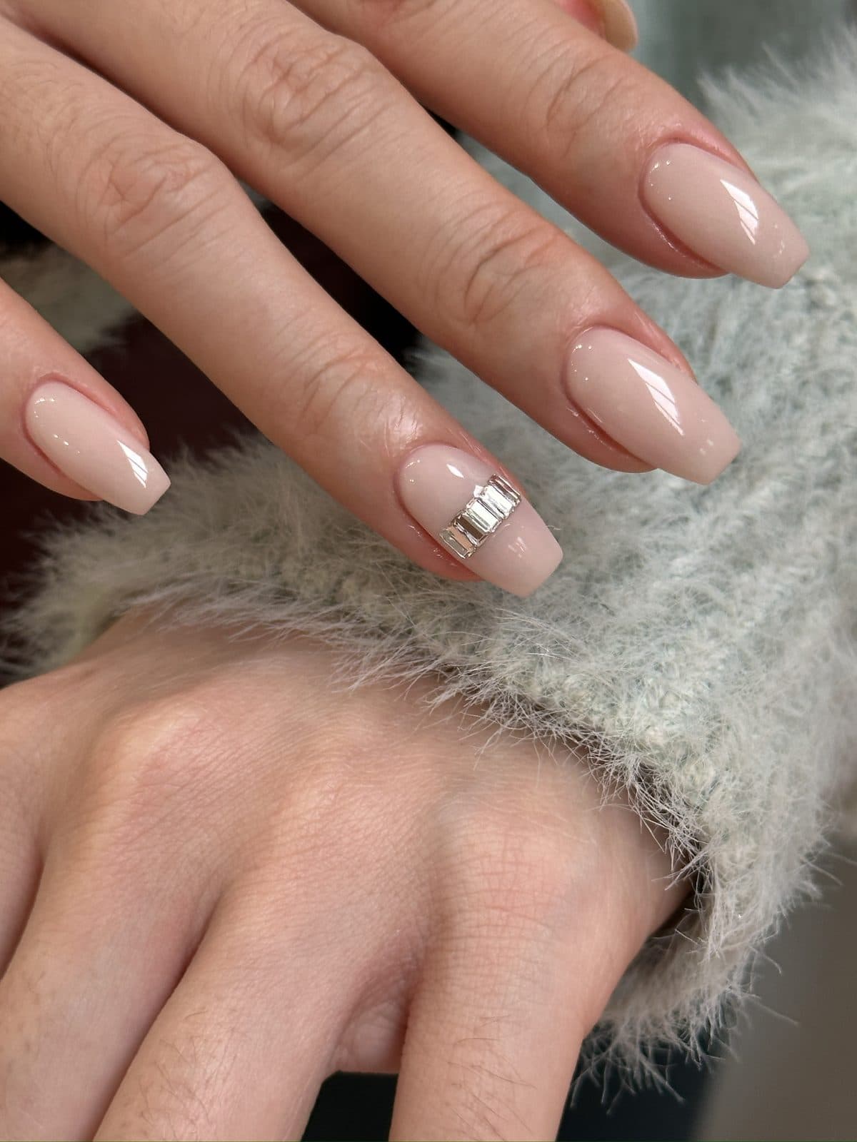 Long coffin gel nails in milky nude with a single silver stud accent at Joy Nail Studio Vancouver