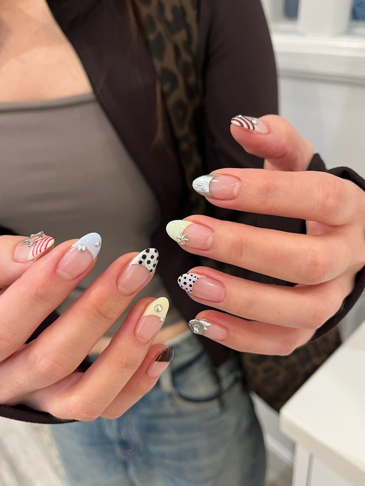 Gel nails with mixed French tips in zebra, polka dot and pale yellow at Joy Nail Studio Vancouver