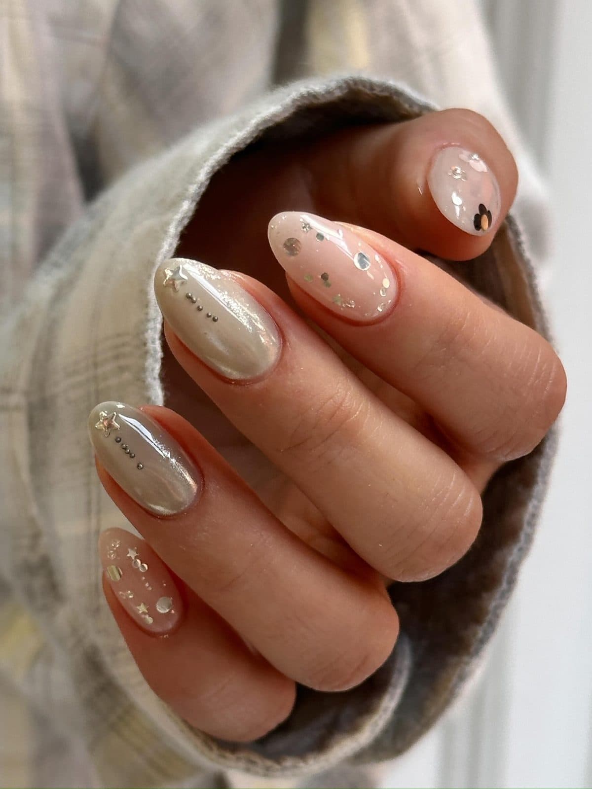 Nude gel nails with gold flakes and fine star and line art at Joy Nail Studio Vancouver