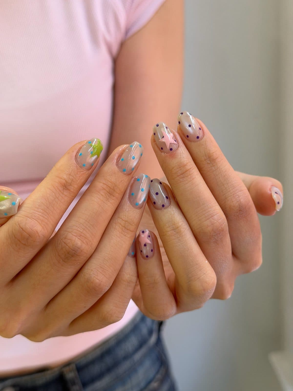 Short gel nails in pastel shades with scattered dot and star art at Joy Nail Studio Vancouver