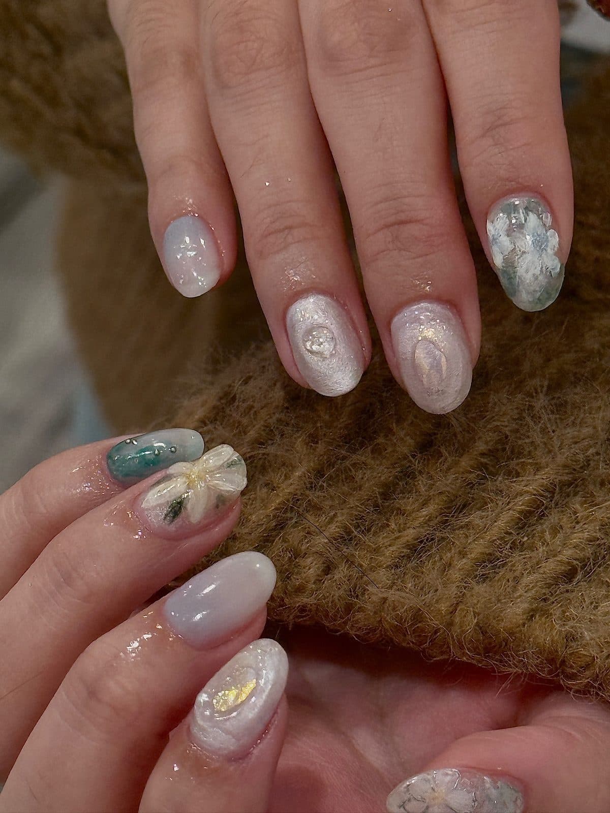 Gel nails in pearl white and teal with real pressed flowers set in gel at Joy Nail Studio Vancouver