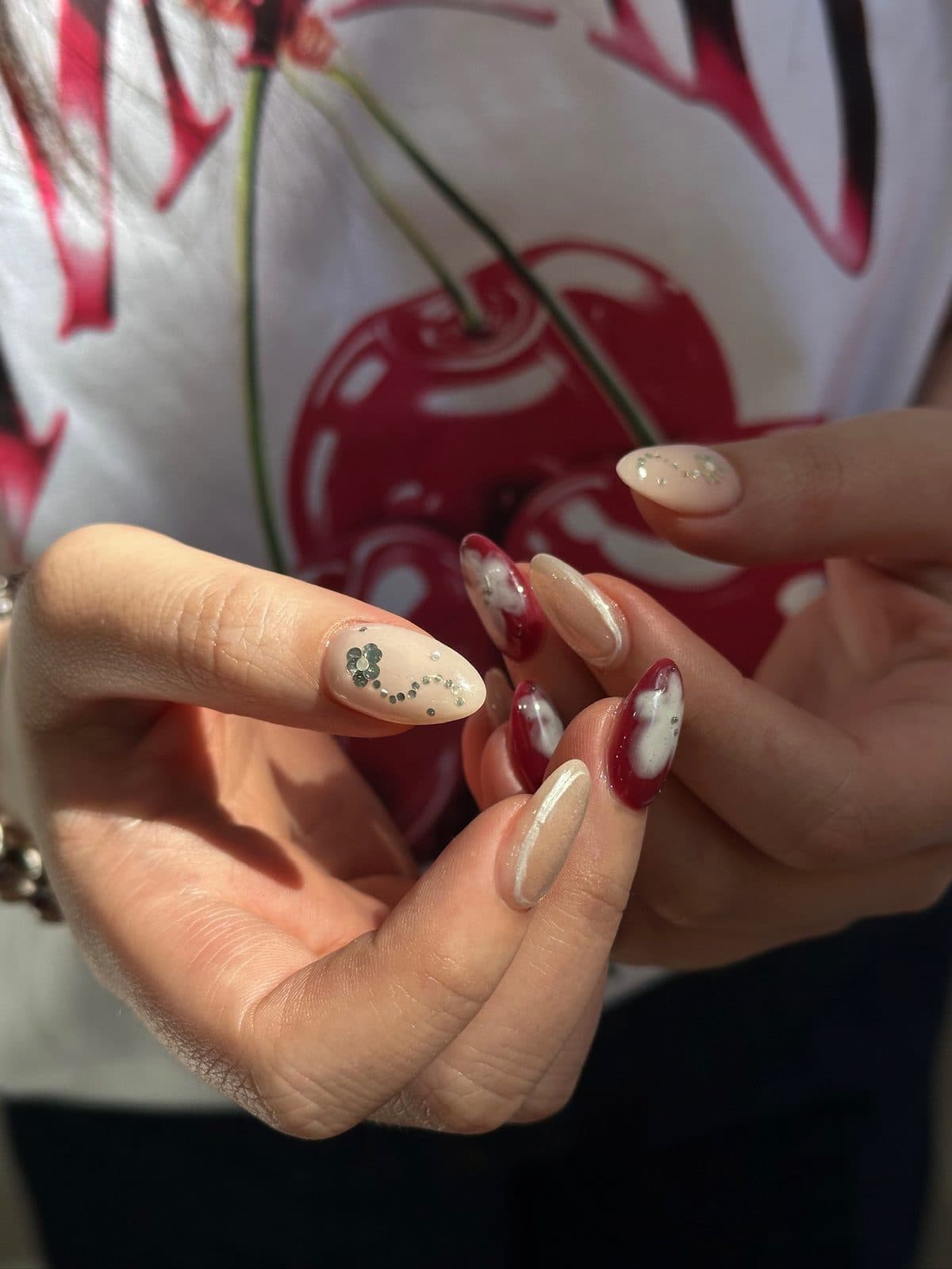 Close-up of hand-painted white flowers on deep red gel extensions at Joy Nail Studio Vancouver