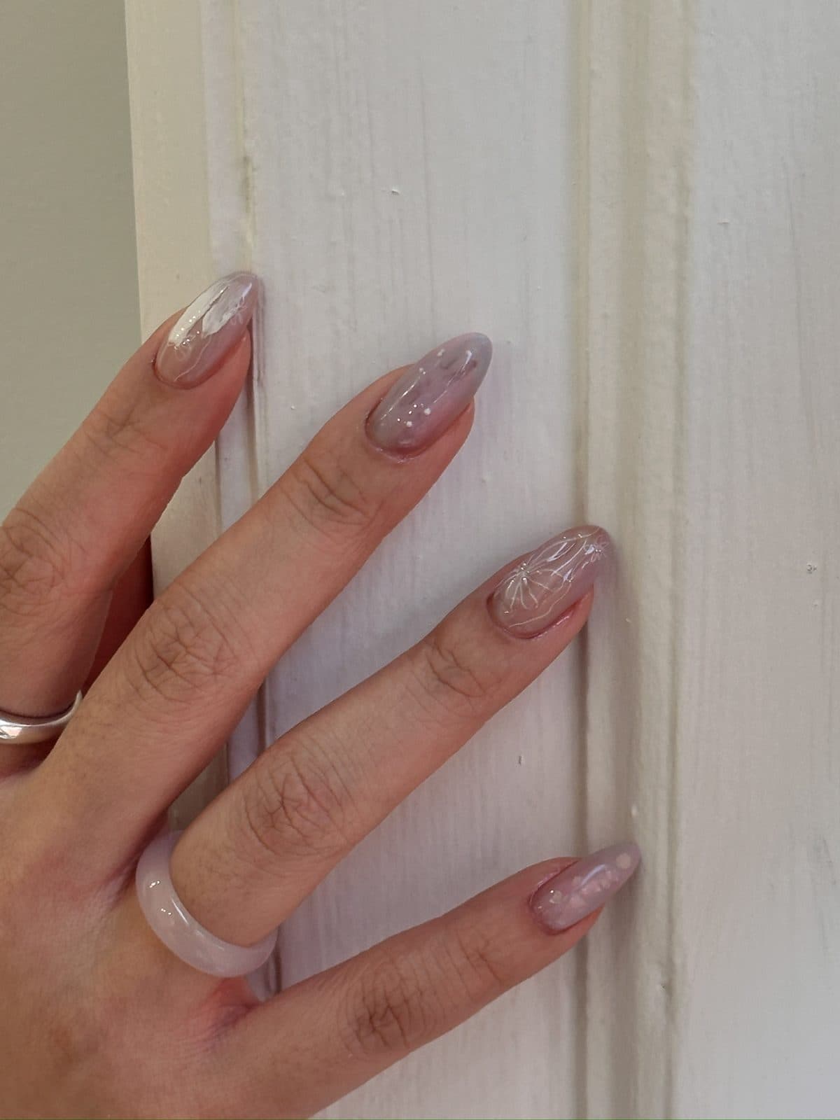 Sheer nude gel nails with fine white flower line art at Joy Nail Studio Vancouver