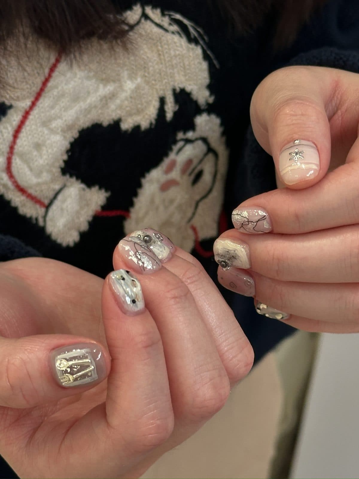 Short gel nails in silver foil with black dot accents at Joy Nail Studio Vancouver