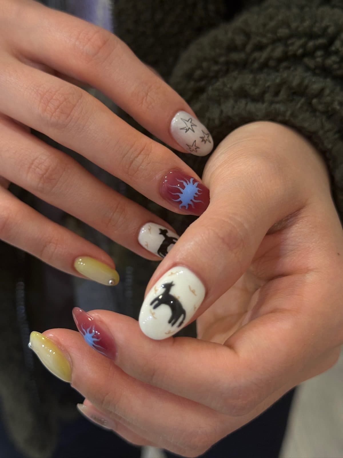 Gel nails in cream and yellow with a hand-painted deer and starburst at Joy Nail Studio Vancouver
