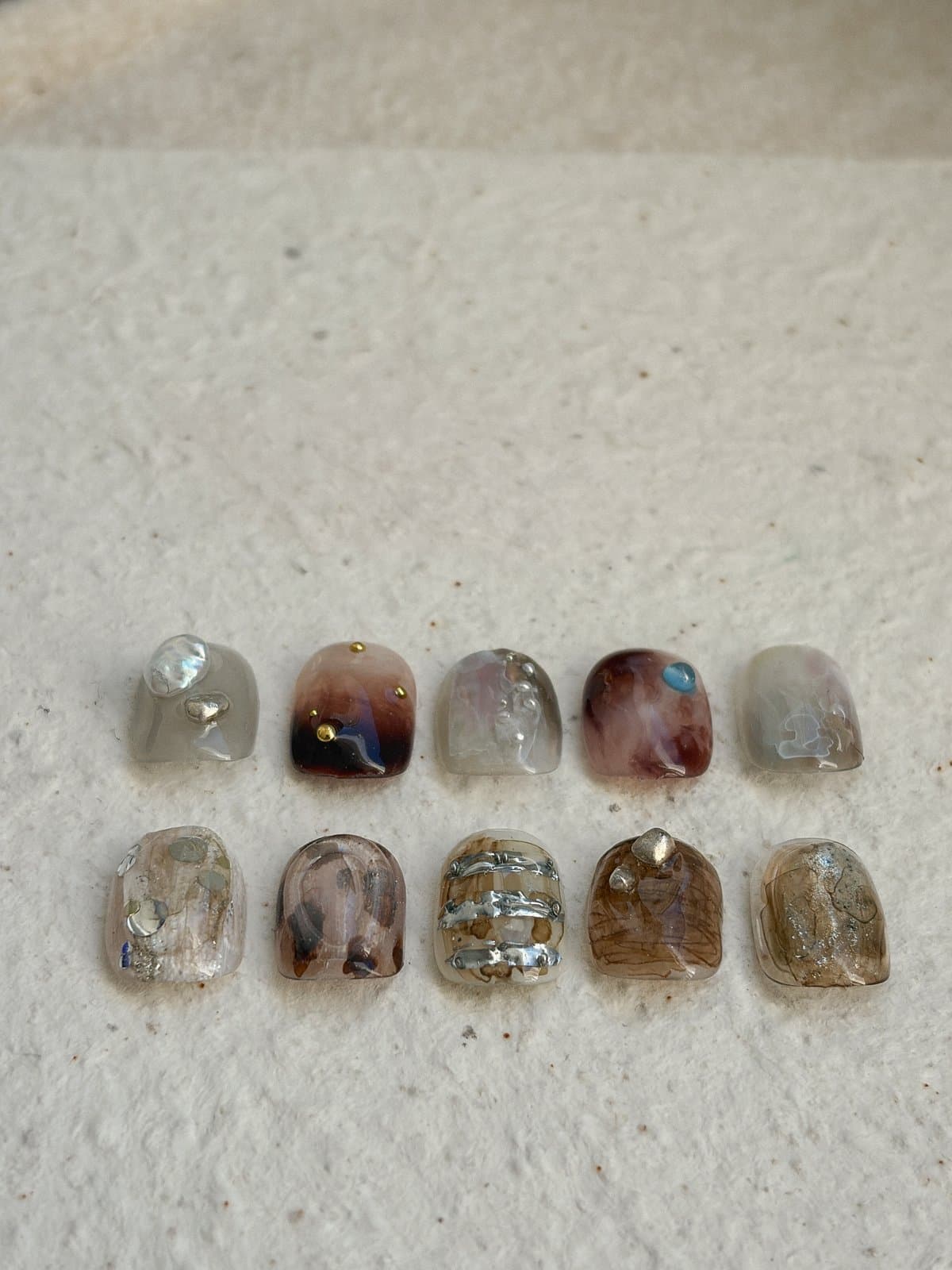 The brown and tortoiseshell nail art tips in two rows with a soft band of shade across the top of the frame and every tip in the light, by Joy Nail Studio Vancouver